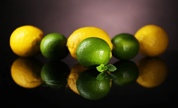 Лимоны и лаймы на темном фоне — стоковое фото
