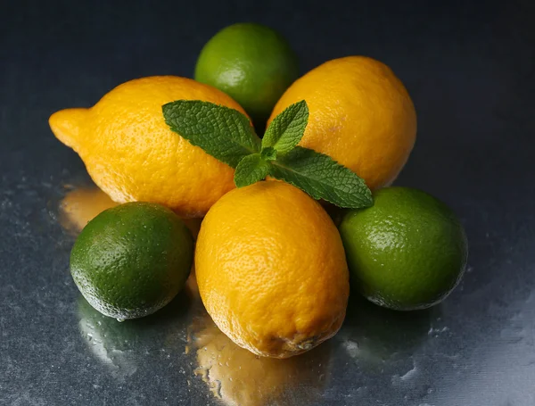 Limoni e lime su fondo scuro — Foto Stock