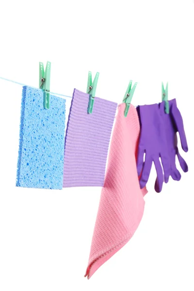 Kitchen sponges and rubber gloves hanging on rope isolated on white — Stock Photo, Image