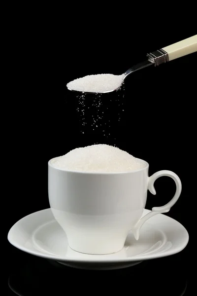 Сахар в чашке изолированы на черный — стоковое фото