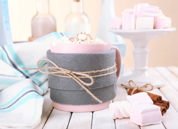 Mug of hot drink decorated in felt on wooden table — Stock Photo, Image