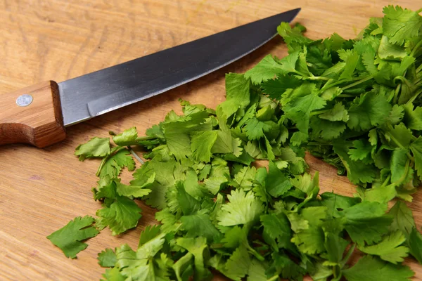 Chopped cilantro on wooden board close-up — Stock Photo, Image