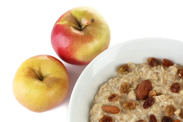 Tasty oatmeal with raisins and apples isolated on white — Stock Photo, Image