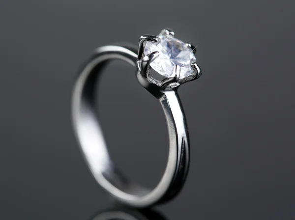 Bellissimo anello di diamanti su sfondo grigio Fotografia Stock