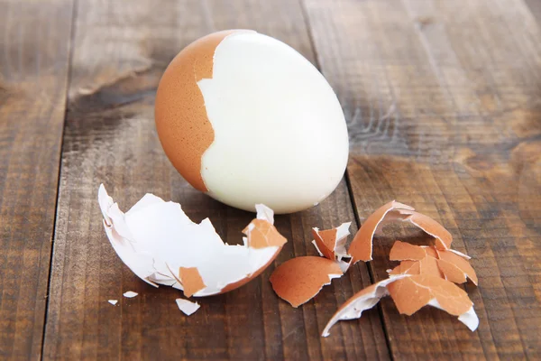 Очищенное яйцо на деревянном фоне — стоковое фото