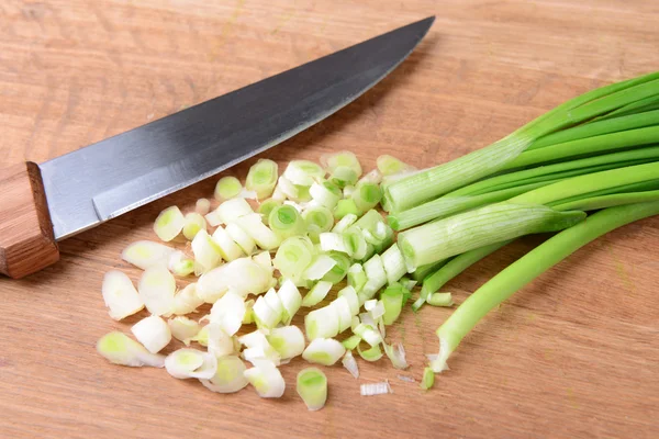 Oignons verts hachés sur une planche en bois close-up — Photo