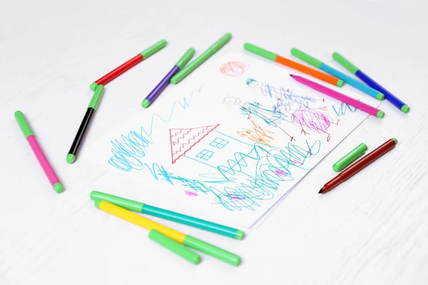 Kids drawing of family and colored pencils on wooden table — Stock Photo, Image