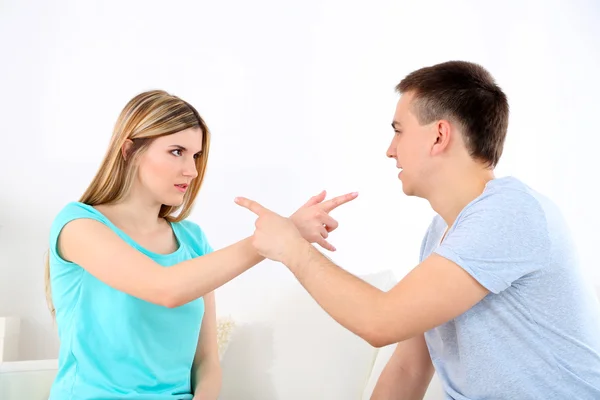 Portrait of young man and woman  conflict sitting on sofa argue unhappy, on home interior background — Stock Photo, Image