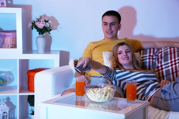 Jovem casal assistindo televisão em casa de apagão — Fotografia de Stock