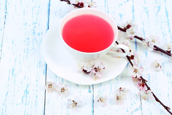 Fragrant tea with flowering branches on wooden table close-up — Stock Photo, Image