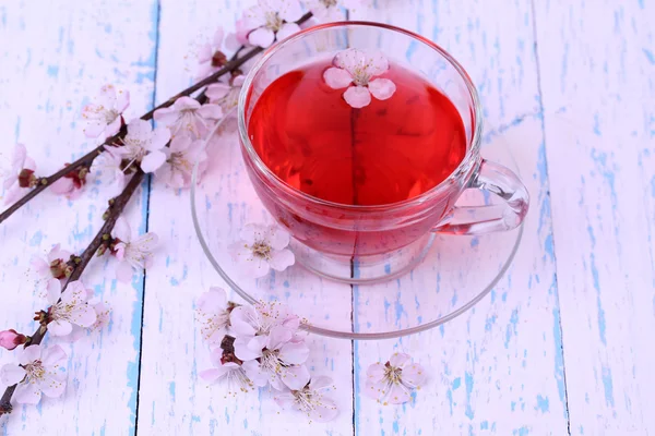 Fragrant tea with flowering branches on wooden table close-up — Stock Photo, Image