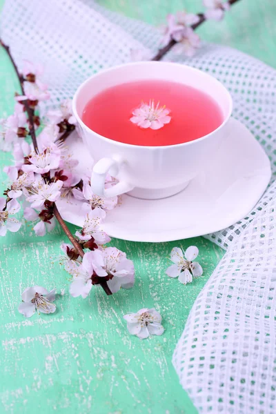 Fragrant tea with flowering branches on wooden table close-up — Stock Photo, Image