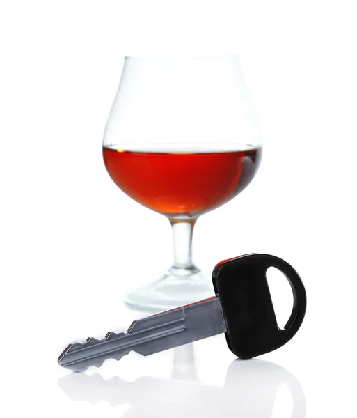 Композиція з автомобільним ключем і склянкою коньяку, ізольована на білому — стокове фото