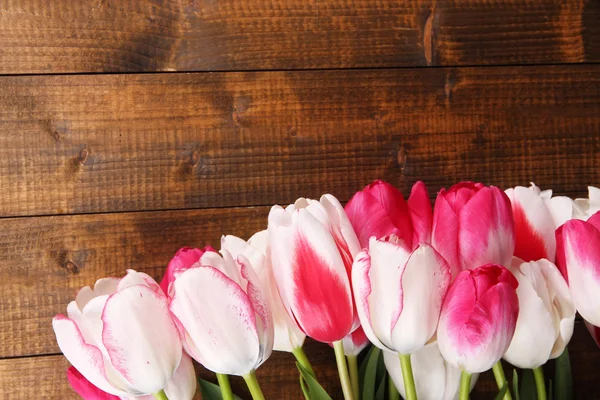 Bei tulipani su sfondo di legno a colori — Foto Stock