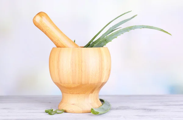 Fresh green aloe leaves in wooden mortar  on wooden table — Stock Photo, Image