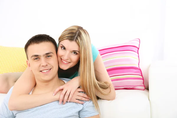 Loving couple sitting on sofa, on home interior background — Stock Photo, Image