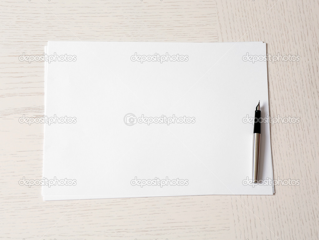 Blank paper and pen on wooden table