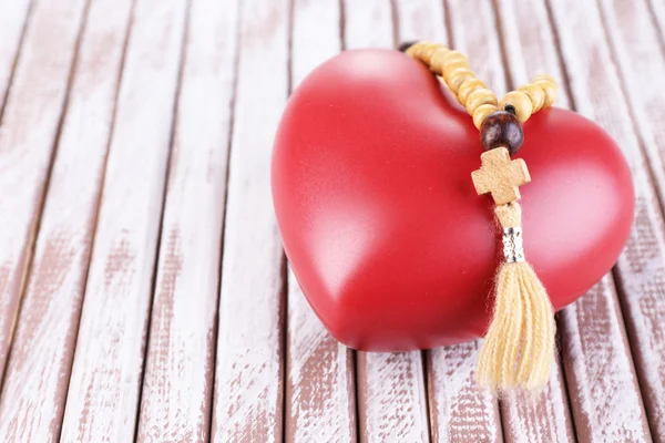 Heart with rosary beads on wooden background — Stock Photo, Image