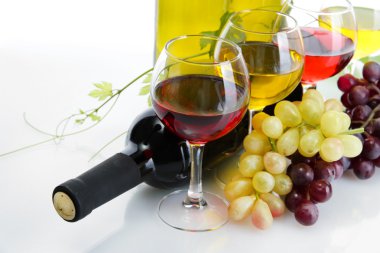 şişe ve bardak şarap ve olgunlaşmış üzümler beyaz izole