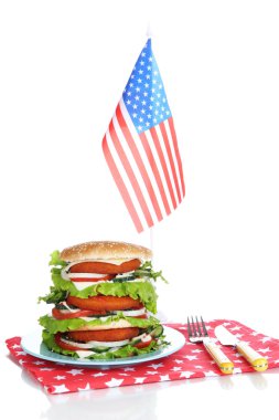 Composition with huge burger on color plate and USA flag, isolated on white