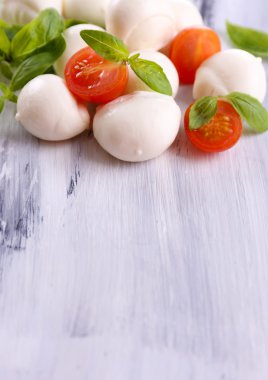 ahşap masa üstünde domates ve fesleğen ile lezzetli mozzarella peyniri