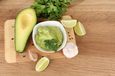 ahşap masa üzerinde kase taze guacamole