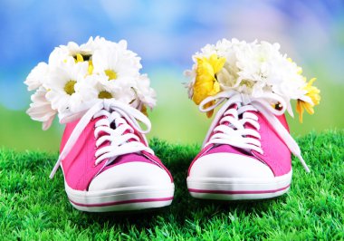 parlak zemin üzerine yeşil çimenlerin üstünde çiçekli güzel lastikbotlar