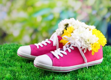 parlak zemin üzerine yeşil çimenlerin üstünde çiçekli güzel lastikbotlar