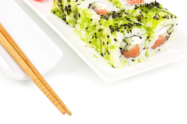 Rouleaux savoureux servis sur plaque blanche avec baguettes isolées sur blanc — Photo