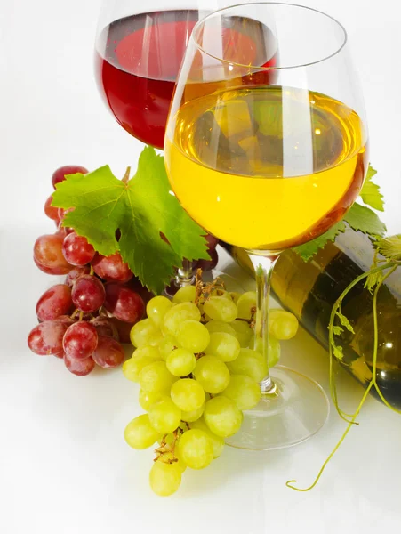 Bottle and glasses of wine and ripe grapes isolated on white — Stock Photo, Image