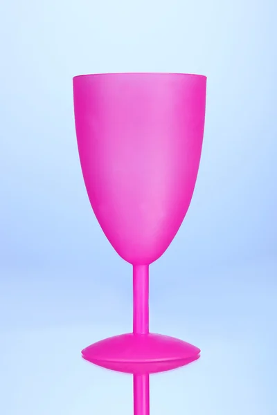 Bright plastic goblet on blue background — Stock Photo, Image