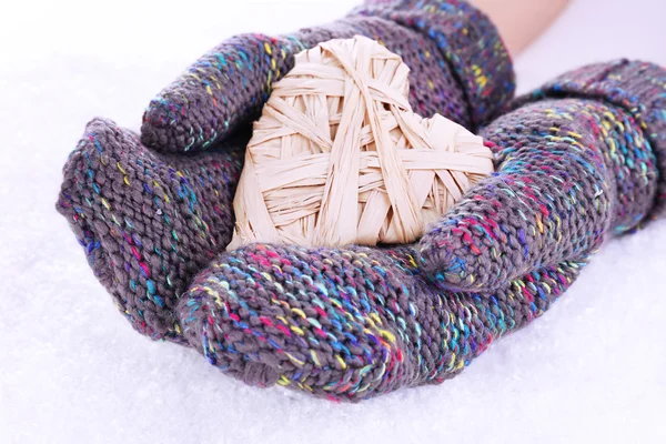 Female hands in mittens with heart on snow background — Stock Photo, Image