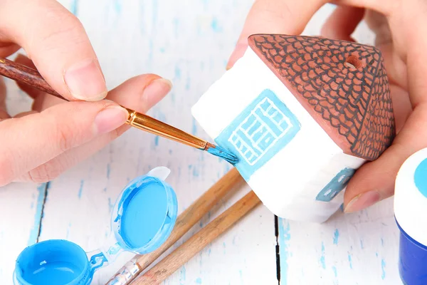 Hands paints on hand made ceramic house and  art materials — Stock Photo, Image