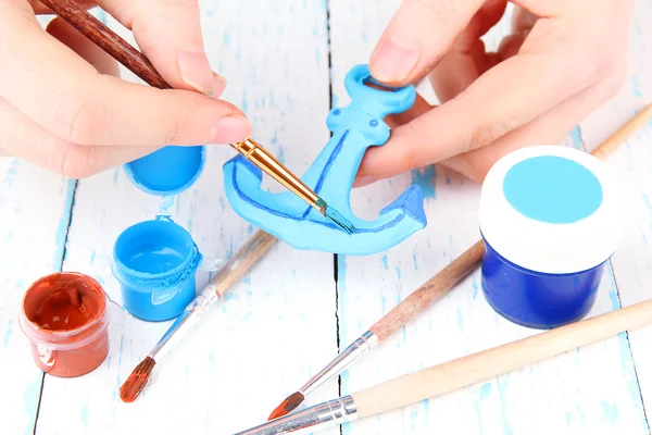 Hands paints on hand made ceramic anchor and art materials — Stock Photo, Image