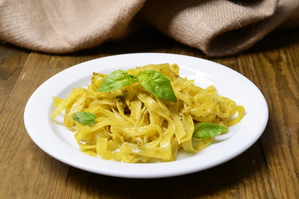 Lezzetli pasta plaka üzerinde tablo yakın çekim pesto ile — Stok fotoğraf