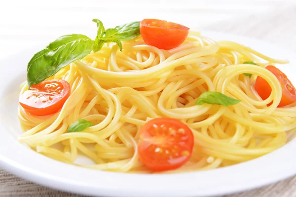 Pyszne spaghetti z pomidorami na tabliczce na stół szczegół — Zdjęcie stockowe