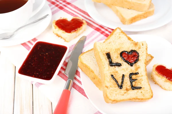 Delicious toast with jam and cup of tea on table close-up — Stock Photo, Image