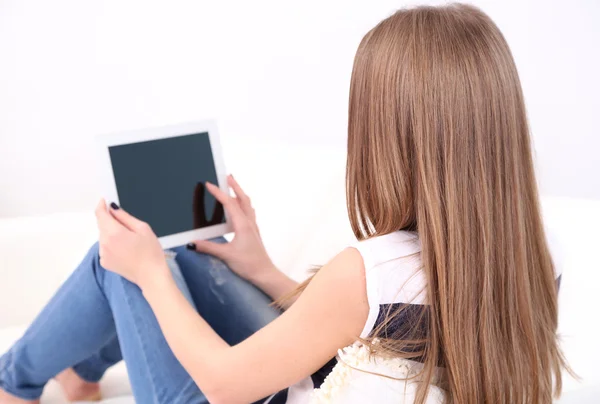 Junge Frau ruht sich mit Tablet auf Sofa zu Hause aus — Stockfoto