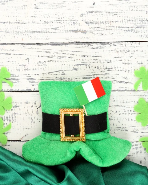 Saint Patrick day hat with clover leaves and Irish flag on wooden background — Stock Photo, Image