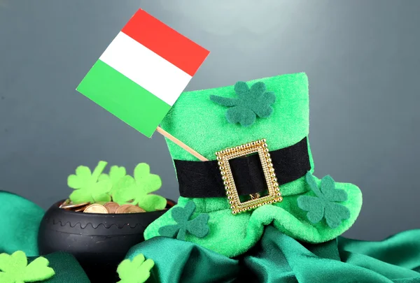 Saint patrick dzień kapelusz, garnek złota monet i Irlandczycy bandery na szarym tle — Zdjęcie stockowe