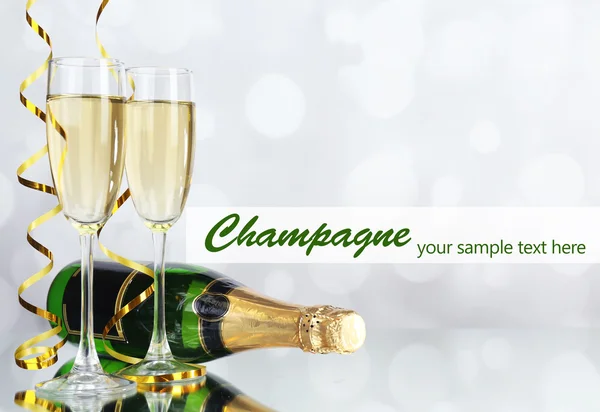 Окуляри та пляшка шампанського на світлому фоні — стокове фото