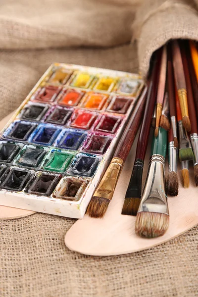 Composição com escovas, aquarelas na paleta de madeira, isolado em branco — Fotografia de Stock