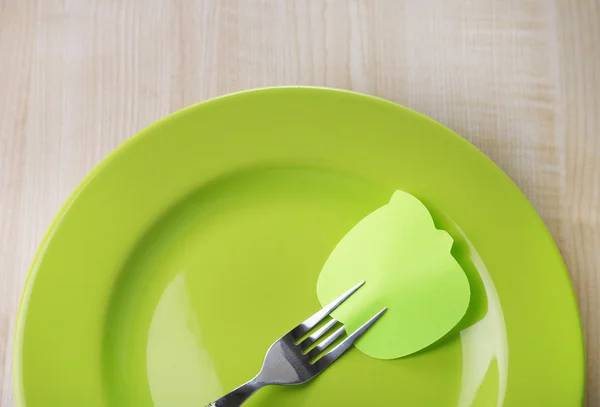 Empty note paper attached to fork, on plate, on color wooden background — Stock Photo, Image