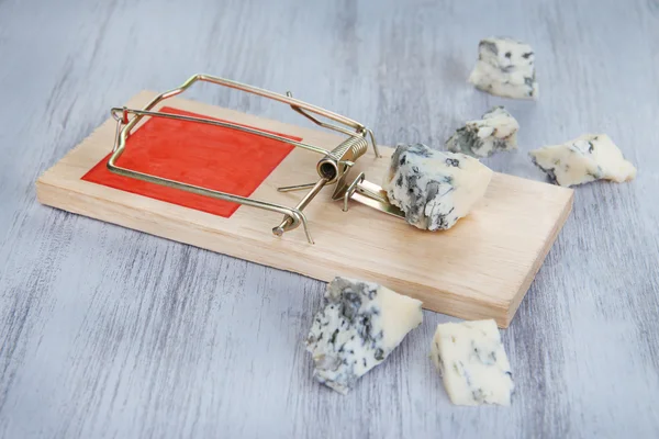 Мышеловка с сыром на деревянном фоне — стоковое фото