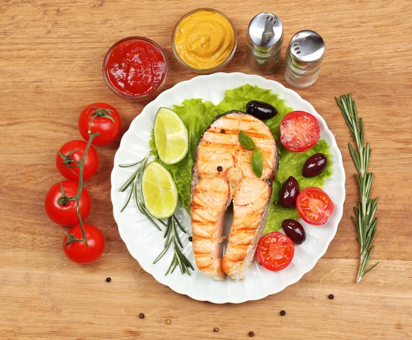 Lekkere gegrilde zalm met groenten, op houten tafel — Stockfoto