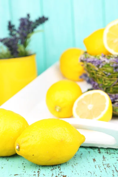 Still life with fresh lemons and lavender on blue background — Stock Photo, Image