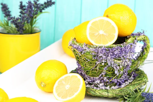 Still life with fresh lemons and lavender on blue background — Stock Photo, Image