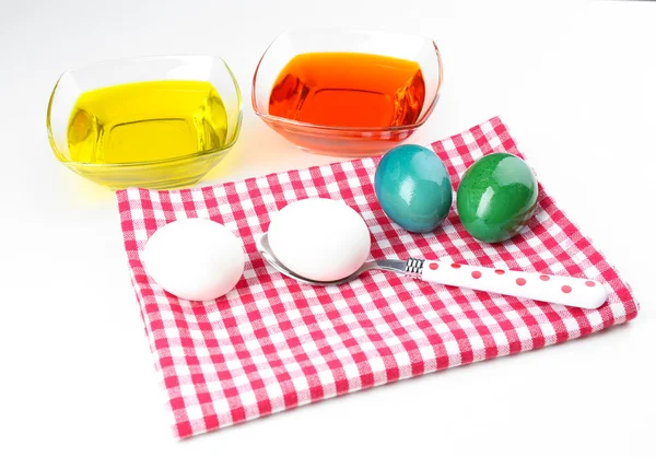 Cuencos con pintura para huevos de Pascua y huevos, aislados en blanco — Foto de Stock