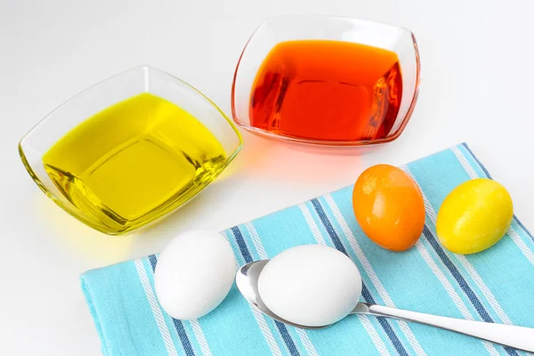 Cuencos con pintura para huevos de Pascua y huevos, aislados en blanco — Foto de Stock