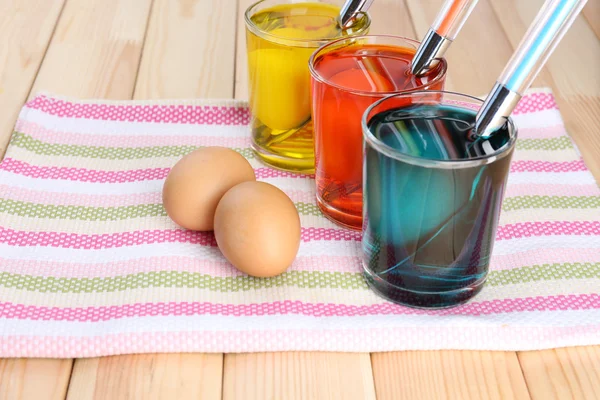 Glasses with paint for Easter eggs and eggs, close up — Stock Photo, Image